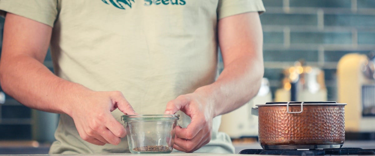 Ingredients for cannabis MCT oil infusion including dried cannabis flower, MCT oil, jar, and strainer