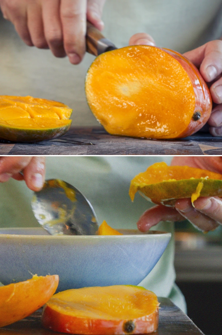 Hands peeling and chopping a ripe mango into small pieces on a cutting board to prepare it for a smoothie.