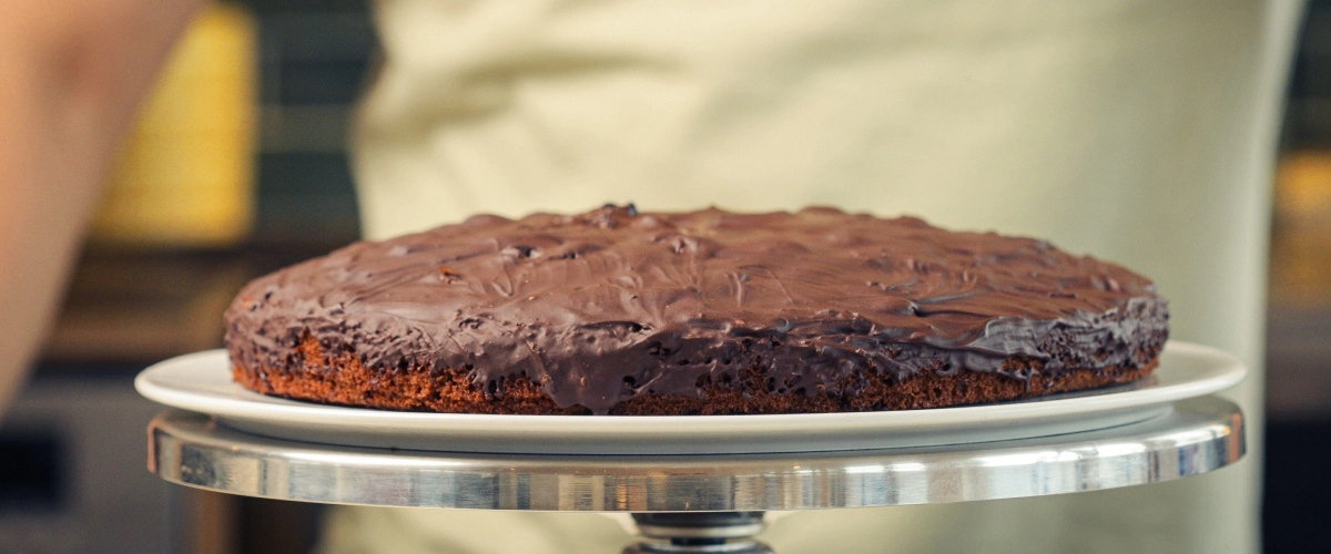 Homemade Cannabis Space Cake – Rich Chocolate Edible Dessert Finished homemade cannabis space cake topped with melted dark chocolate, served as a classic edible dessert