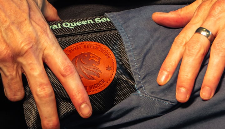 Smell-Proof Bag for Discreet Cannabis Storage Image of hands placing a smell-proof cannabis storage bag into a pocket.