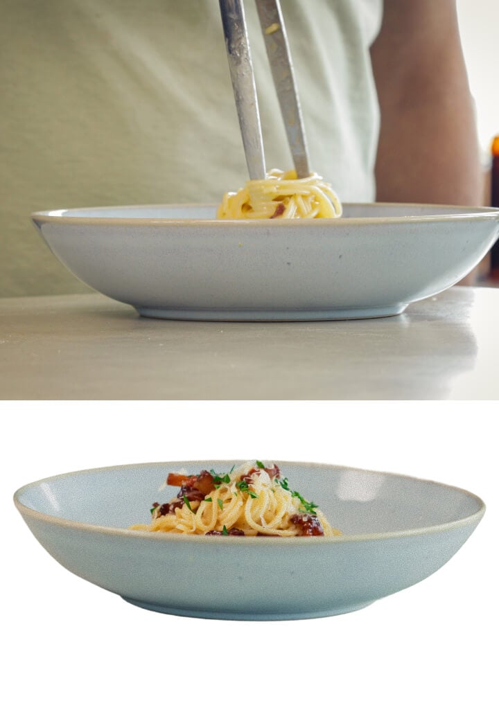 Plating creamy cannabis-infused spaghetti carbonara with pancetta and grated cheese, final step before serving
