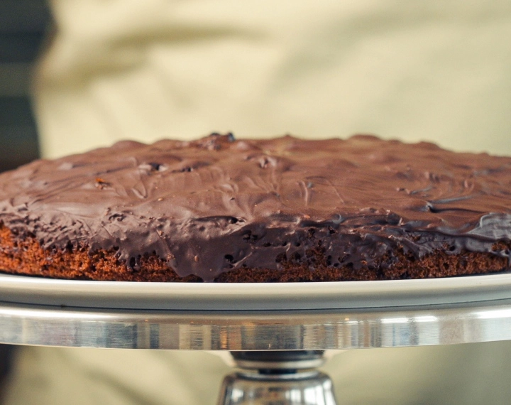 Finished homemade cannabis space cake topped with melted dark chocolate, served as a classic edible dessert